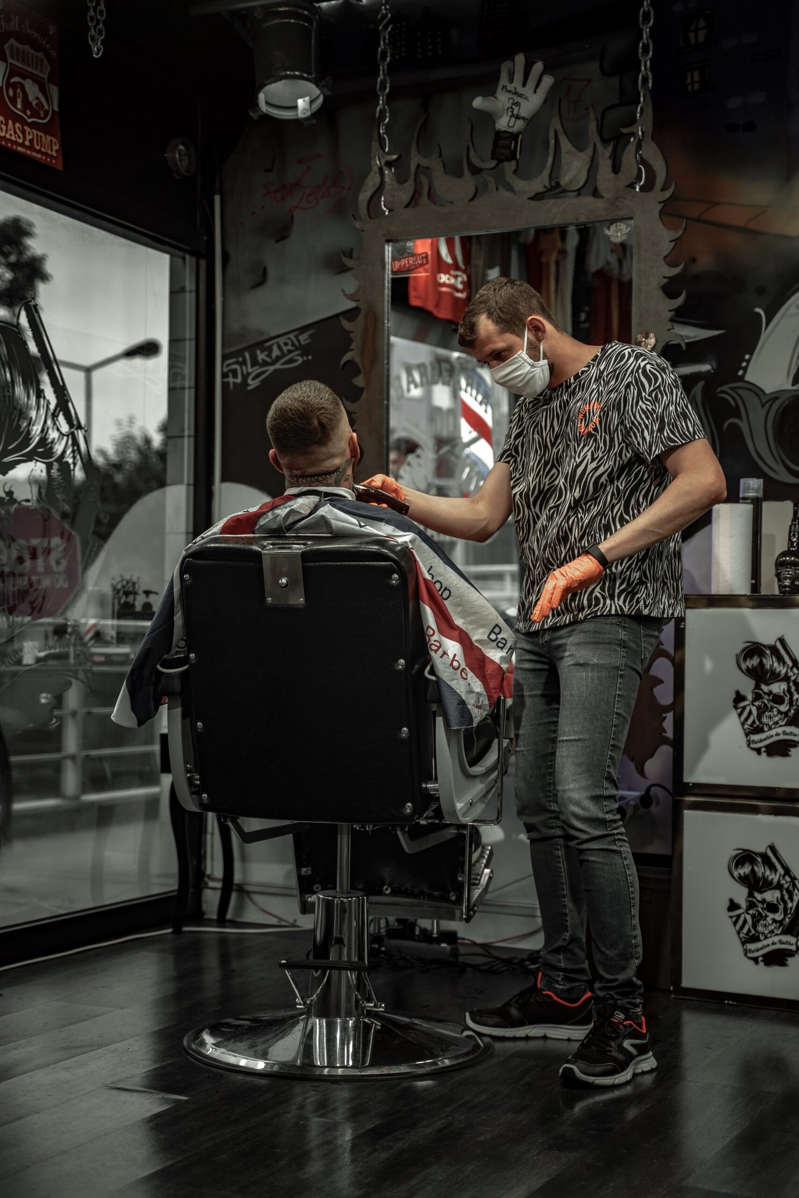 man in black and white shirt sitting on barber chair